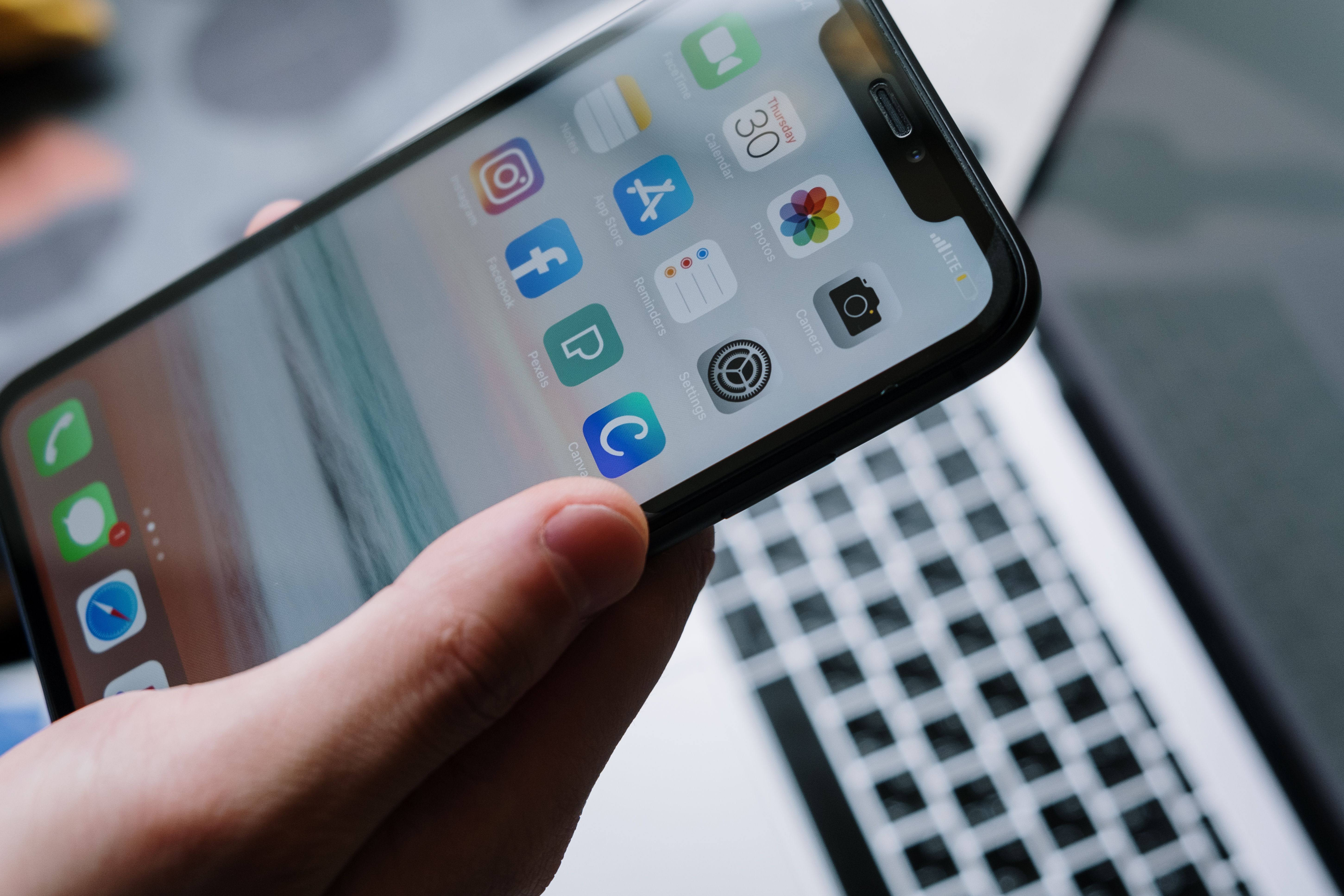 Person holding a smartphone showing app icons